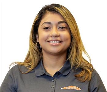 Female employee in SERVPRO shirt in front of white backdrop