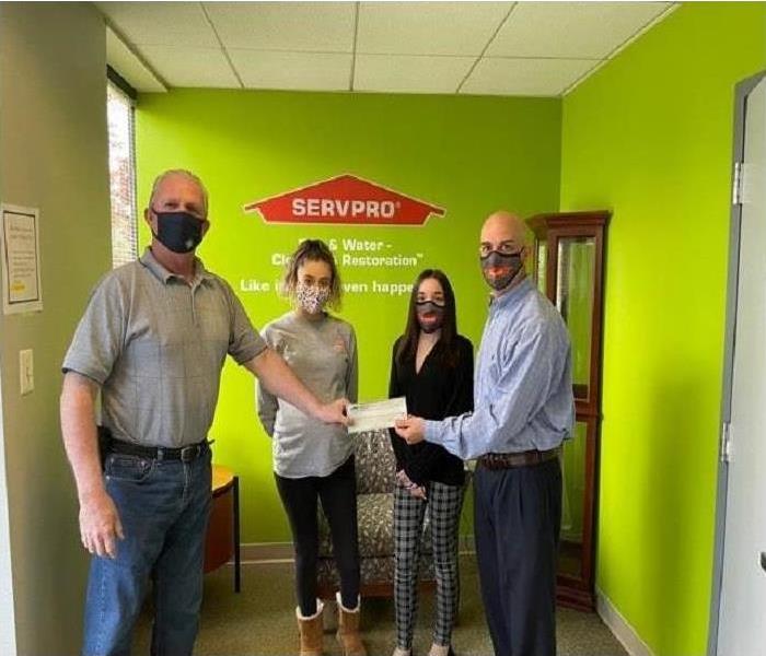 SERVPRO Team giving donation check