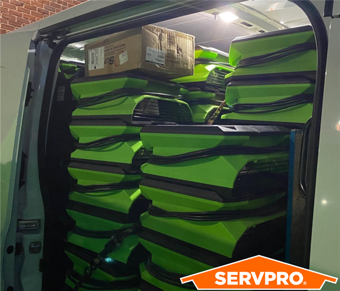 A white Van completely filled with green air movers
